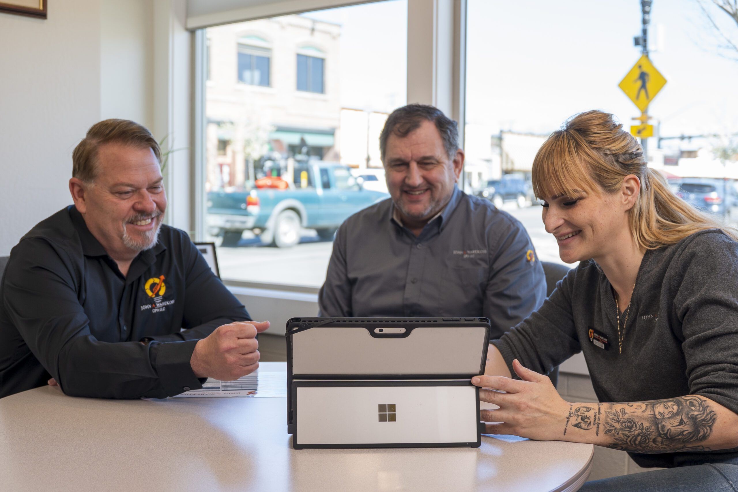 John Warekois, Darren Olsen, and Rachelle looking over an ipad