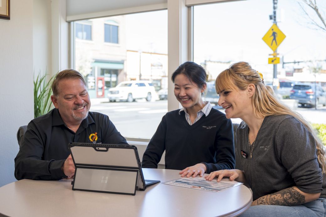 John Warekois, Annie, and Rachelle looking at a tablet