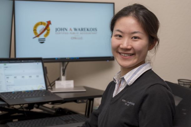 Annie, a CPA, sitting in front of her desk